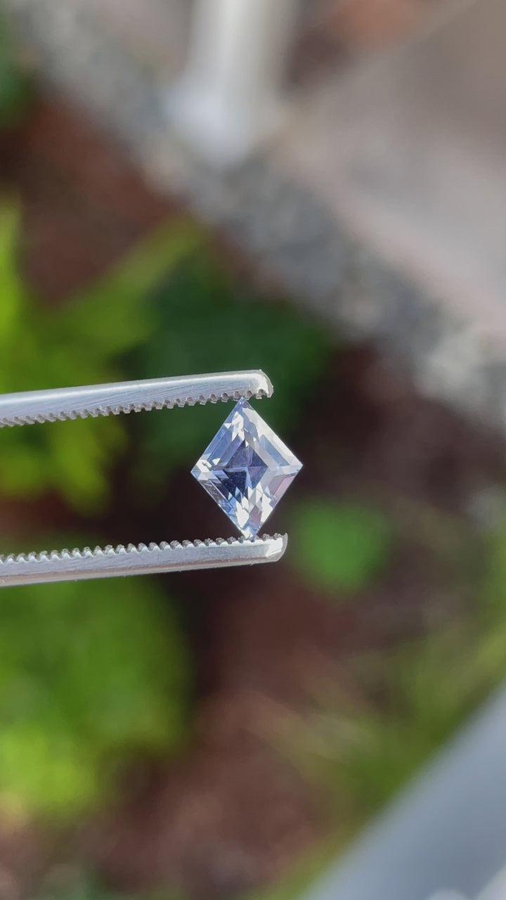 Detailed video of a 1.53 carat kite step-cut sapphire with violet and blue tones. Captured in natural light to display its brilliance and clarity.