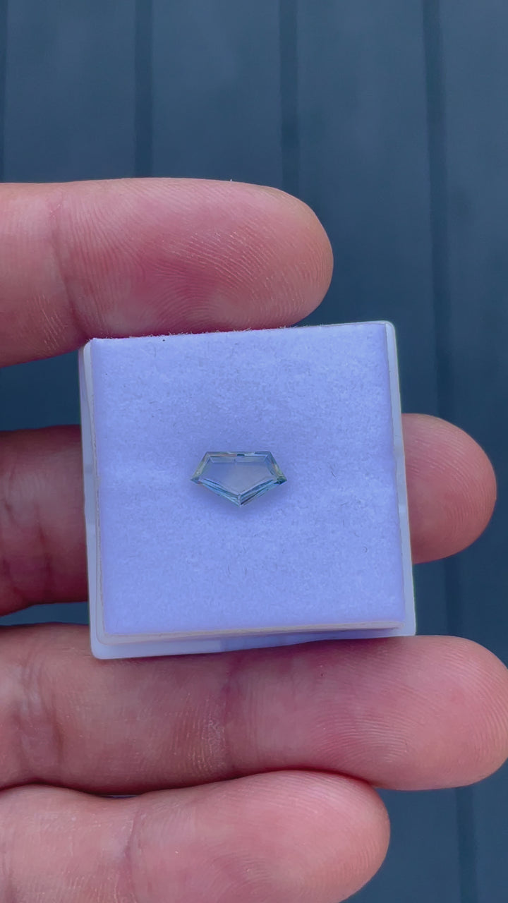 Detailed rotation view of a geometric step cut sapphire, focusing on its precise cut and depth, along with its striking color shift effects, recorded to display the gemstone's overall quality and allure.